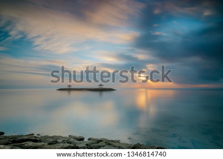 Long exposure of a sunrise with reflection in the Indonesian sea on the island of Bali. great reflection and calm picture mood
