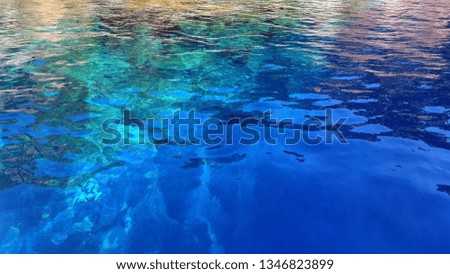 A picture of a blue sea water with underwater rocks