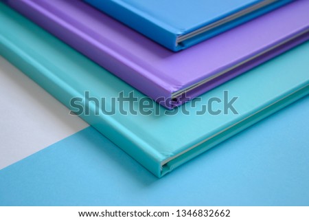 stack of multicolored books on a neutral background
