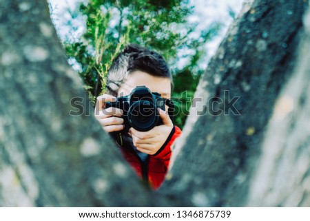 Boy with dslr camera photographing. Teen boy with camera taking pictures.