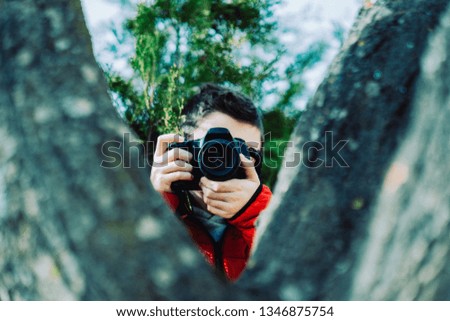 Boy with dslr camera photographing. Teen boy with camera taking pictures.