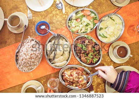 Bhutanese meal with chili cheese red rice, cheesy potato, chicken and vegetables Royalty-Free Stock Photo #1346887523