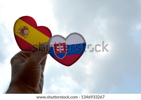 Hand holds a heart Shape Spain and Slovakia flag, love between two countries