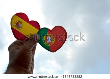 Hand holds a heart Shape Spain and Portugal flag, love between two countries