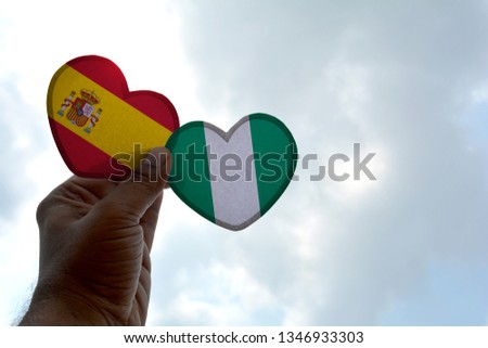 Hand holds a heart Shape Spain and Nigeria flag, love between two countries