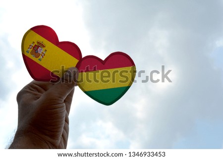 Hand holds a heart Shape Spain and Bolivia flag, love between two countries
