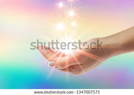 Healing hands with bright sunburst on rainbow background Royalty-Free Stock Photo #1347007571