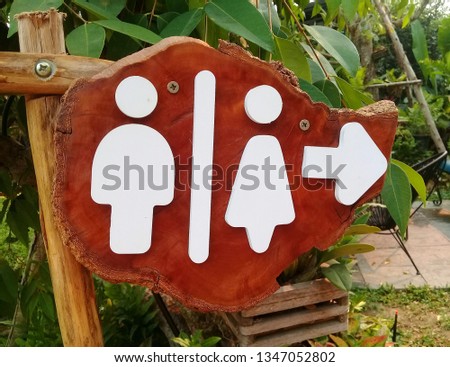 Wooden sign, male and female bathroom.