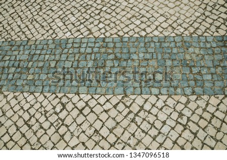 Close-up of white and blue stone pavement in square shape on a sunny day, forming an odd background at Campo Maior. A cute little town with Roman, Moorish and medieval influences in eastern Portugal.