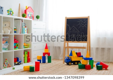 Children's playroom with plastic colorful educational blocks toys. Games floor for preschoolers kindergarten. interior children's room. Free space. background mock up chalkboard Royalty-Free Stock Photo #1347098399