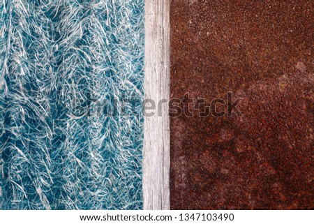 Abstraction of blue textolite slate, fiberglass background in half with a rusty metal plate and a dividing strip of wood