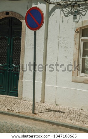 NO WAITING road sign and mansion facade with cracked wall on sunny day, in front of deserted causeway at Campo Maior. A little town with Roman, Moorish and medieval influences in eastern Portugal.