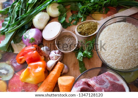 products for cooking pilaf meat with rice on fire in cauldron