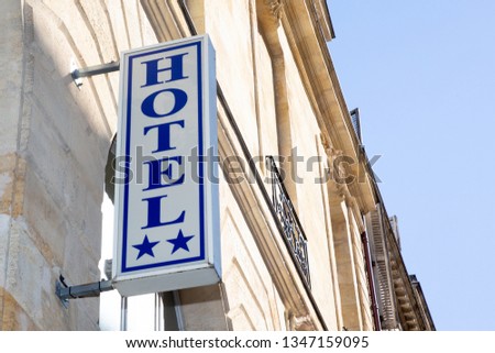Hotel sign write in blue with two stars on white background in facade building street