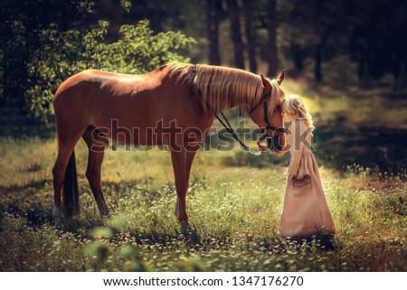 a girl in a long dress and a brown horse are standing in a summer park with daisies and bowing their heads to each other
