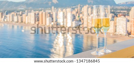Two glass of champagne against Levante Beach, Benidorm, Valencia, Spain