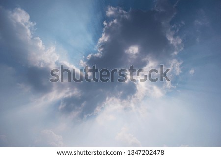 A sunny day blue sky photograph with clouds and sun ray