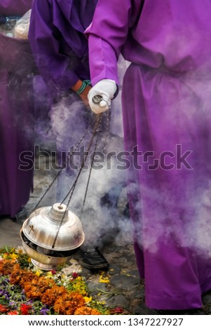 A penitent spreading incense in a procession during Holy Week in Antigua Guatemala. Royalty-Free Stock Photo #1347227927