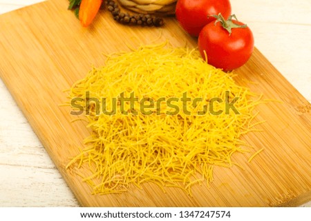 Raw noodle ready for bowling over wooden background