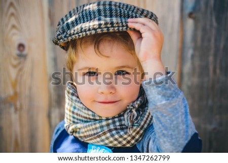 Young boy in a suit, old style picture. Child in garden on wooden background. Old fashion. School boy.