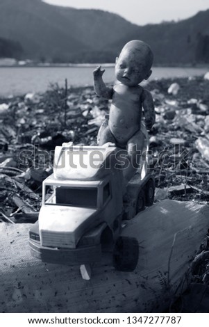 traveler in Ukraine, Kolochava village, photographed a panorama of ecological disaster - in  spring the river carries plastic trash to Europe, abandoned by non-cultural people. Doll symbolizes trouble