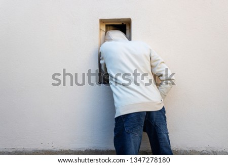 Burglar or thief or robber is stealing with arm through the small window