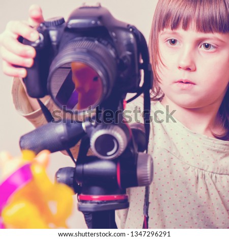 Shot of a little cute child girl photographer at work at home. Selective focus on eye.