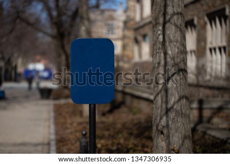 empty blue sign on stone pathway with old classic building in background
