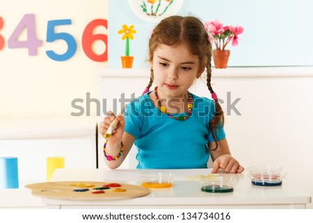 little girl painting a picture