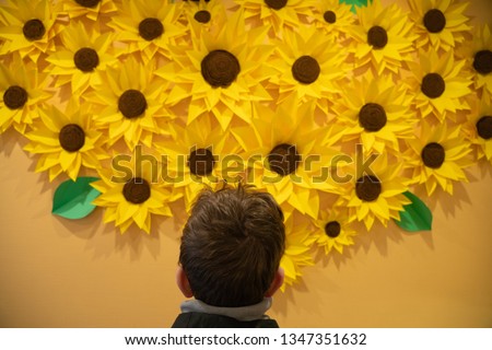 beautiful handmade origami paper sunflowers on the wall. many yellow beautiful flowers.