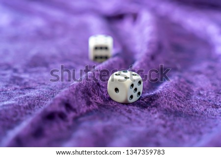 Two dice on a purple velvet background