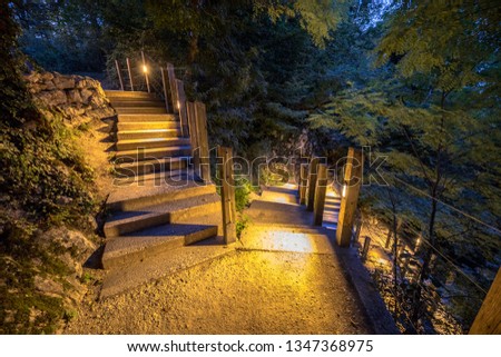 Illuminated outdoor Stairway down rocky mountain park at night