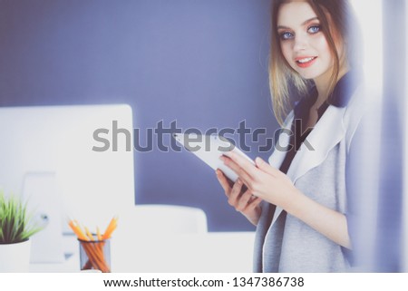 Young businesswoman standing in front of a table in the office