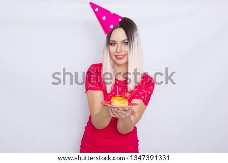 Portrait of beautiful blonde woman in party hat celebrating her birthday. Concept