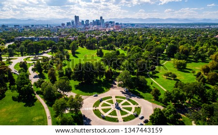 City park green spaces circle pattern monument aerial drone view high above Denver , Colorado Downtown skyline in background with Rocky Mountains