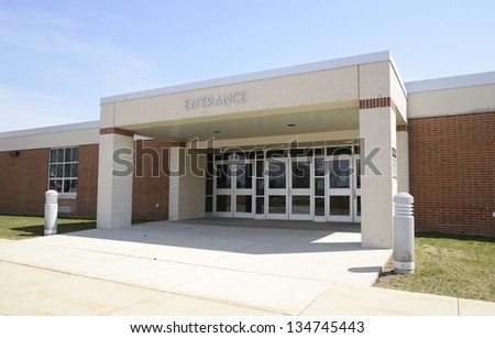 entrance for a modern school, with a covered entryway and sidewalk