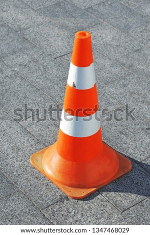 Plastic orange traffic cone on city street