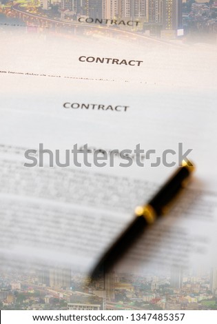 Contract paper with pen and cityscape photo in bacground, concept for real estate business join venture.