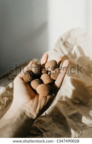 Lychee fruit is held in hand on a paper background. stock food photography