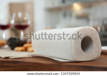 Roll of paper towels on table in kitchen, space for text