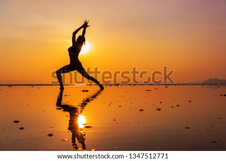 Silhouette of a young woman on the beach at sunset
