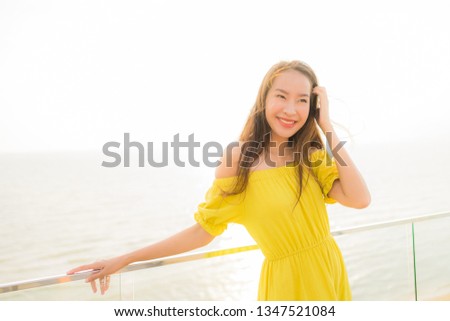 Portrait beautiful young asian woman smile happy and relax at outdoor balcony with sea beach and ocean view for leisure travel and vacation