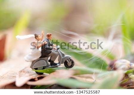 Miniature people : Couple riding the motorcycle in the garden  , Valentine's Day concept