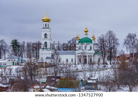 Orthodox church on a hill behind a fence on a winter day