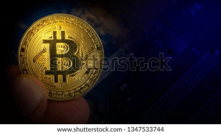 real gold bitcoin coin on mainboard of computer with colored lights in dark composition