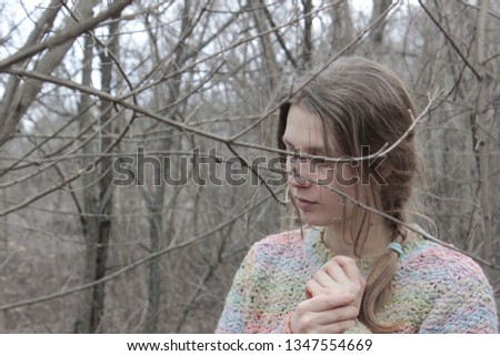 Young and beautiful blonde girl,  standing between branches