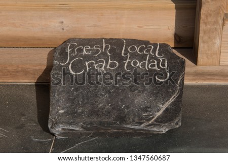 "Fresh Local Crab Today" Hand Written on a Flint Stone at Chapel Porth Beach on the South West Coast Path between Perranporth and Portreath in Rural Cornwall, England, UK