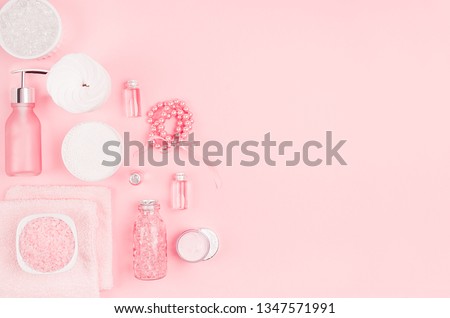 Gentle soft pink cosmetic set for body and skin care, makeup - cream, soap, essential oil, cotton pad, sponges, jewelry, gift box, bath salt, towel on pink background.