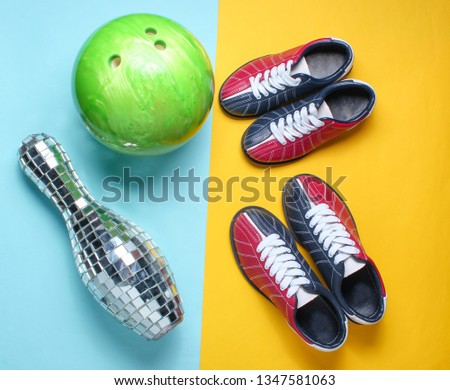 Bowling shoes, disco mirror skittle and bowling ball on blue yellow background. Indoor family sports. Top view. Minimalism