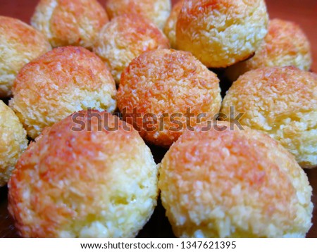 Screensaver of Golden balls of coconut cookies. Cookie balls close-up
